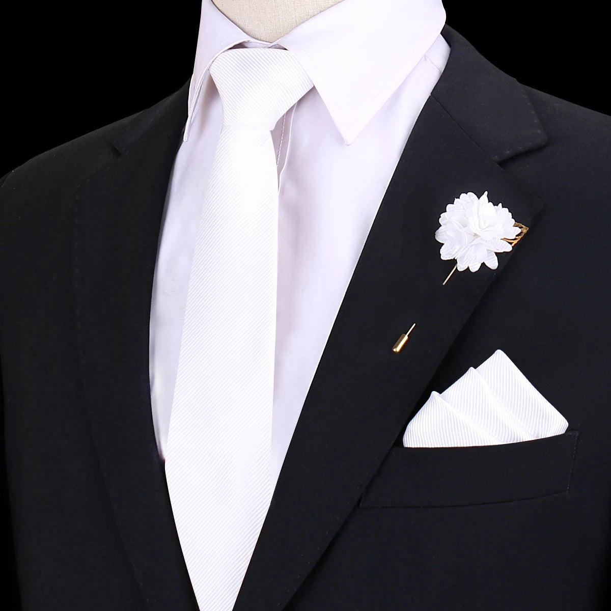 Chaqueta negra con camisa blanca, corbata de seda blanca y una flor en la solapa.