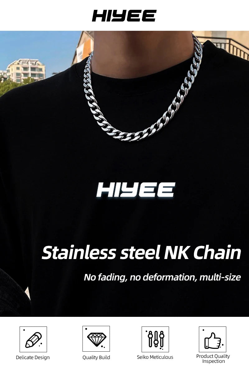 A close-up of a silver stainless steel NK chain necklace worn around the neck against a black shirt.