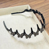 A black sparkling butterfly clip headband displayed in a light-colored box.