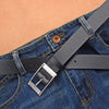 A close-up of a dark gray PU leather belt with a silver metal pin buckle worn on blue denim jeans.