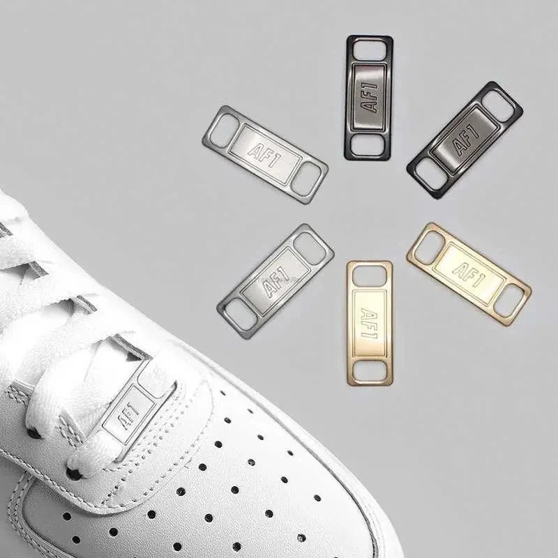 Close-up of white shoe laces with metallic silver and gold diamond charms attached.