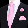 Chaqueta negra con corbata de seda a rayas rosas y flor prendida en pañuelo rosa