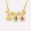 Collier pendentif ton or avec trois petites figurines ornées de pierres CZ scintillantes.