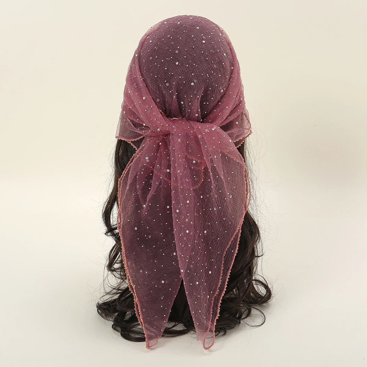 Durchsichtiger mauvefarbener Mode-Hijab mit glitzernden Details, zu einem Knoten gebunden.