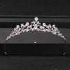 A silver crystal rhinestone bridal tiara headpiece displayed on a dark surface.