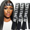 A woman with long dark hair wears a black lace headband with the word LOVE printed on it.