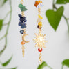 A long gold tassel featuring various colored gemstone beads and a sun charm.