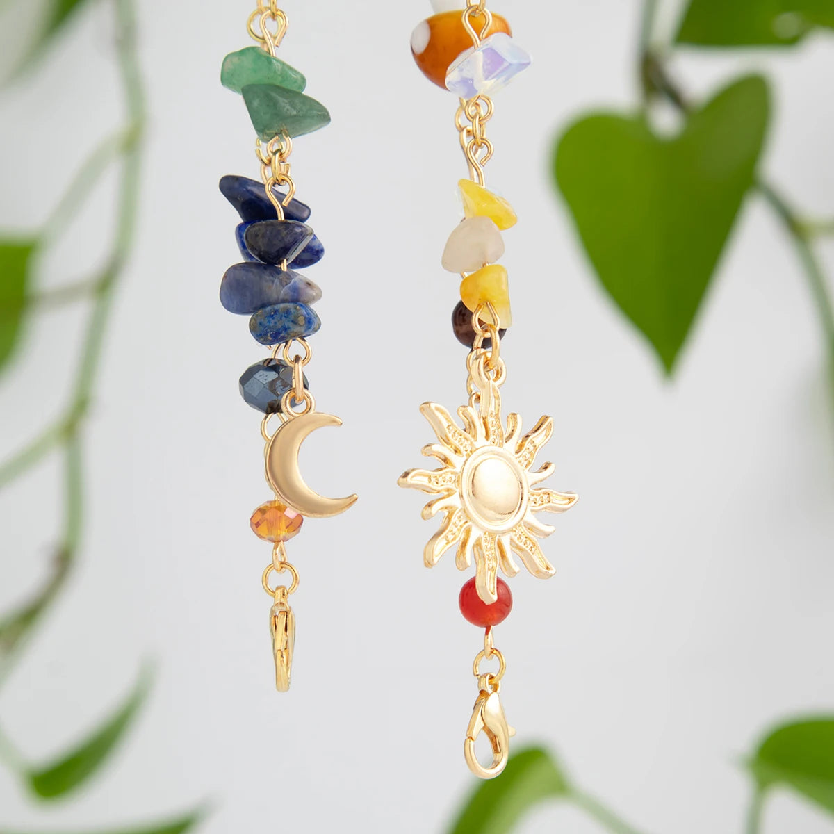 A long gold tassel featuring various colored gemstone beads and a sun charm.