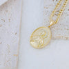 A gold-plated pendant necklace featuring a detailed depiction of the Virgin Mary Christ.