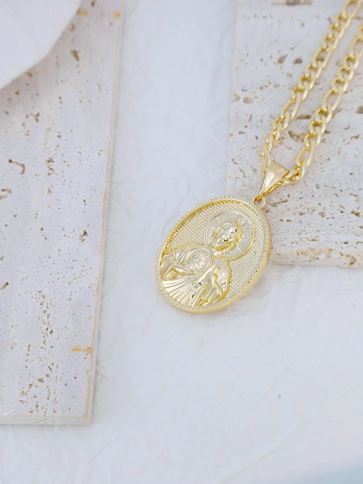 A gold-plated pendant necklace featuring a detailed depiction of the Virgin Mary Christ.