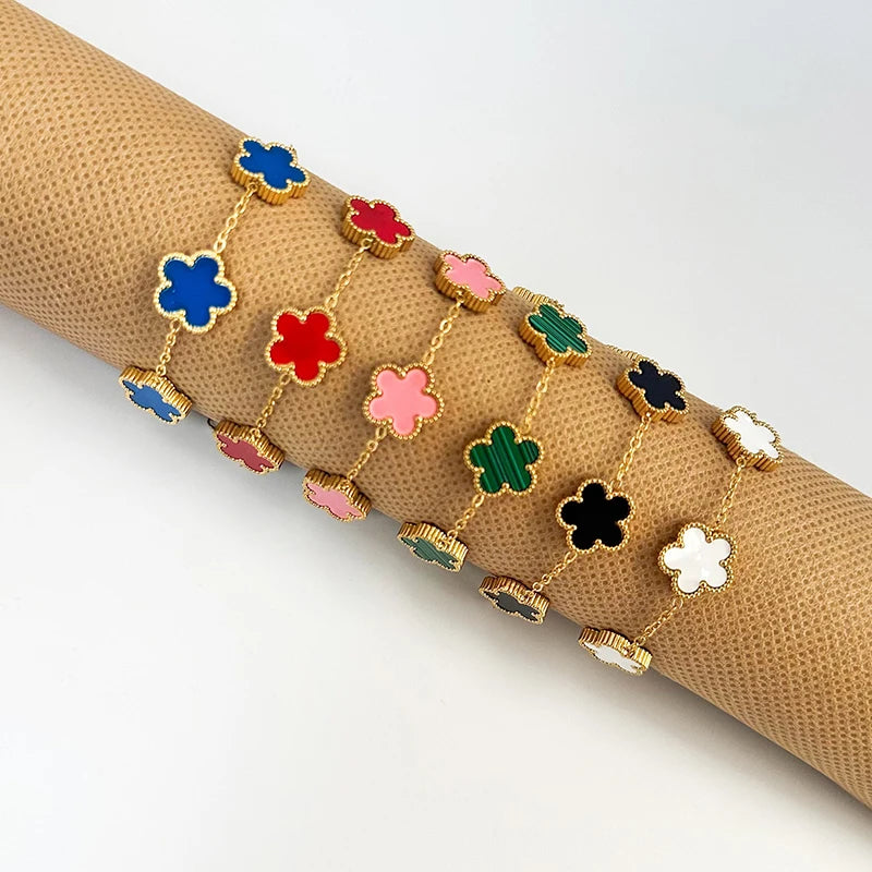 A line of gold plated stainless steel double-sided petal bracelets in various colors like blue, red, pink, green, and black.