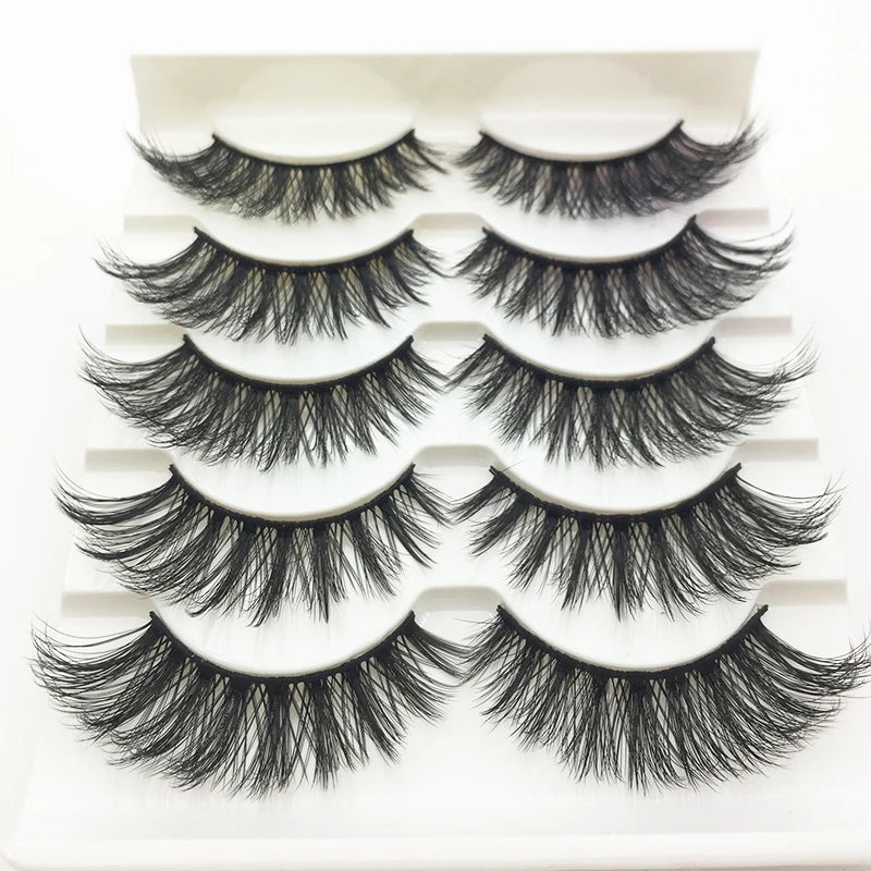 A display of various handmade 3D mink false eyelashes in black on a white tray.