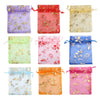 A collection of nine satin drawstring jewelry pouches in various colors and floral patterns.
