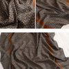 Nahaufnahme eines braun-cremefarbenen, geometrisch gemusterten luxuriösen Baumwoll-Pashmina-Schalsgewebes.