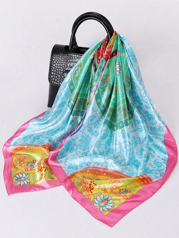 A luxury silk square scarf in shades of turquoise, pink, and gold is draped over a black hanger.