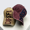 A close-up of a maroon velvet embroidered letter baseball cap with tan fabric and brown lettering.