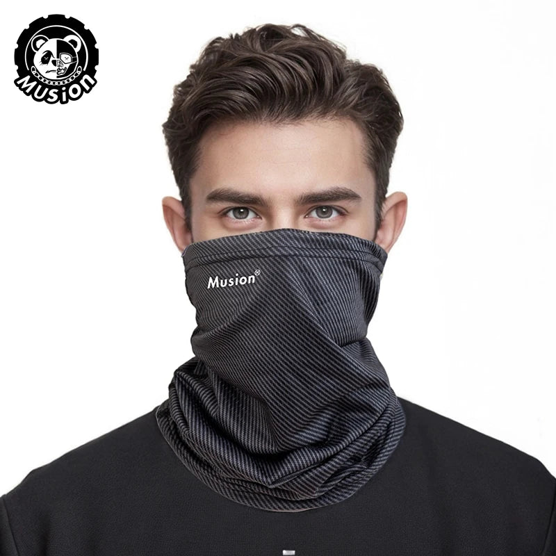 A man wearing a black patterned mask scarf around his neck.