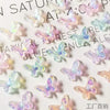 A collection of 10 resin nail art charms shaped like butterflies in various pastel colors