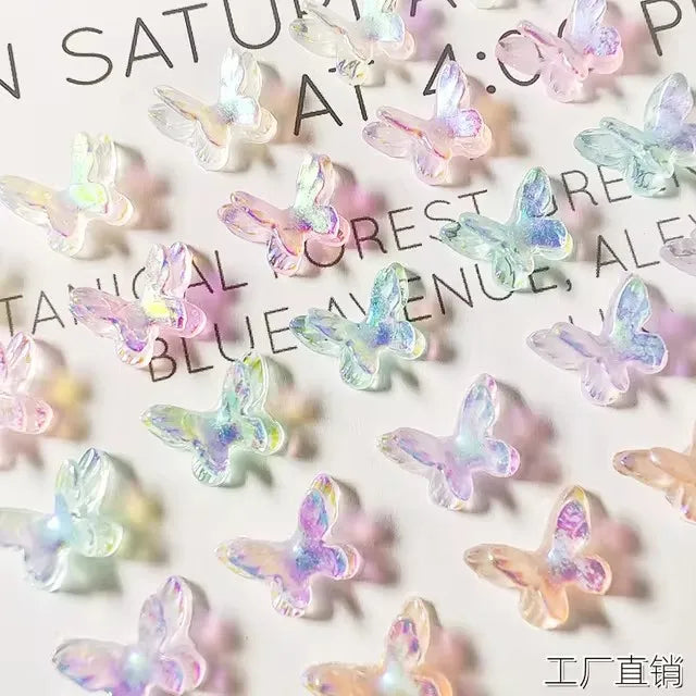 A collection of 10 resin nail art charms shaped like butterflies in various pastel colors