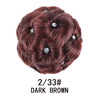 A dark brown synthetic curly hair bun clip-in hairpiece with small silver accents.