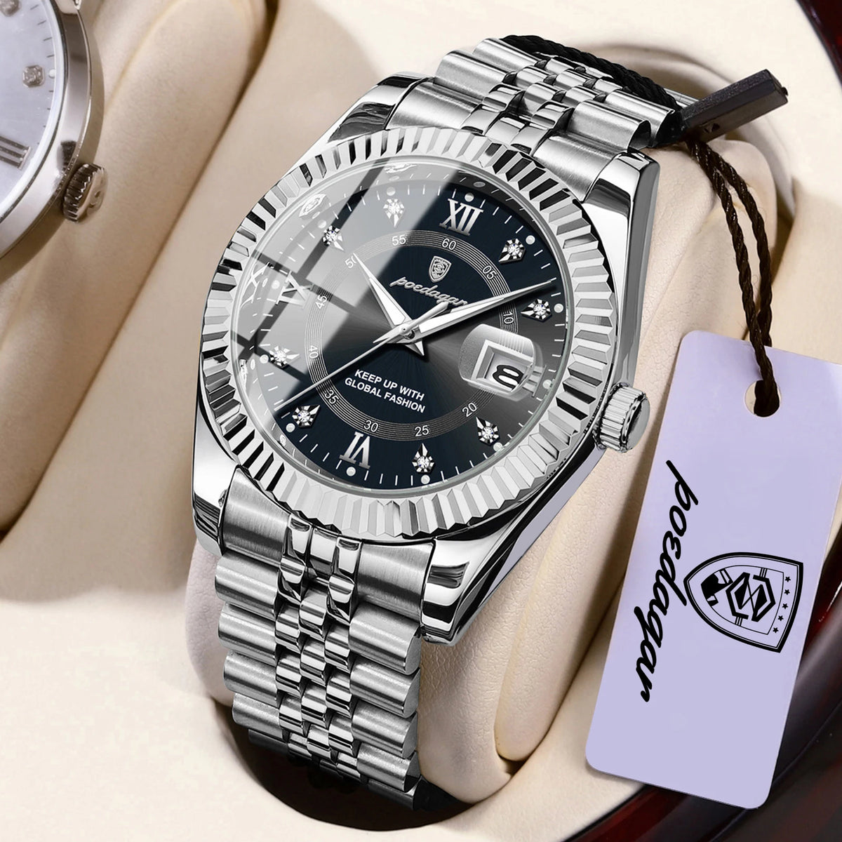 Montre en acier inoxydable argenté avec bracelet en cuir noir et étiquette violette, présentée sur une surface claire.
