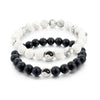 A string bracelet featuring alternating white and black beads with Yin Yang symbols.