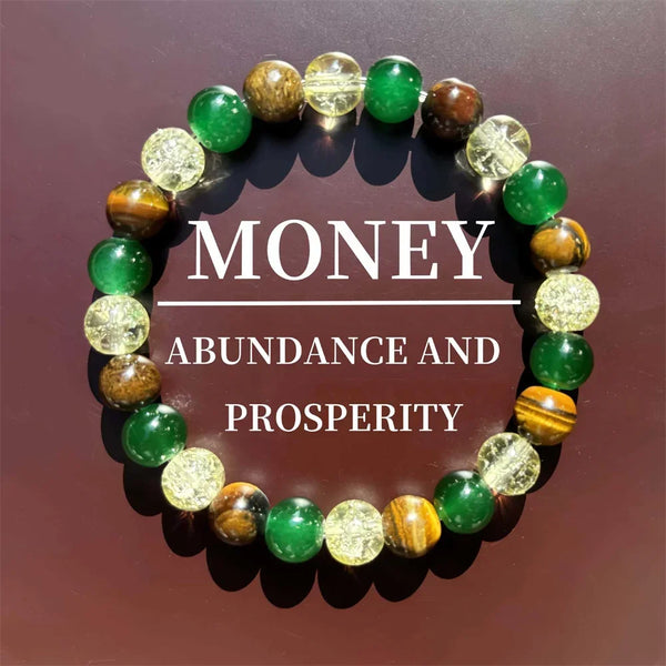 A bracelet made of natural stone and wooden beads, featuring green and amber stones, displayed on a dark background.