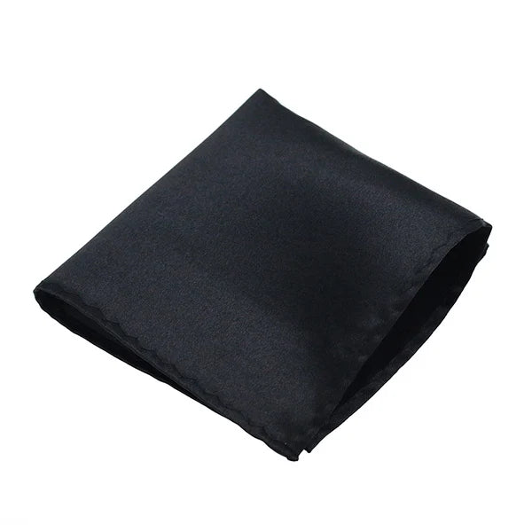 Ein gefaltetes schwarzes Seiden-Einstecktuch diagonal vor weißem Hintergrund.