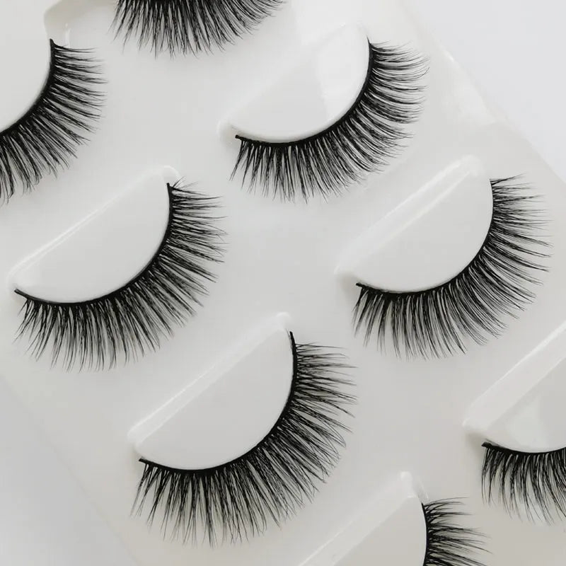 A collection of black handmade mink strip eyelashes displayed on a white surface.