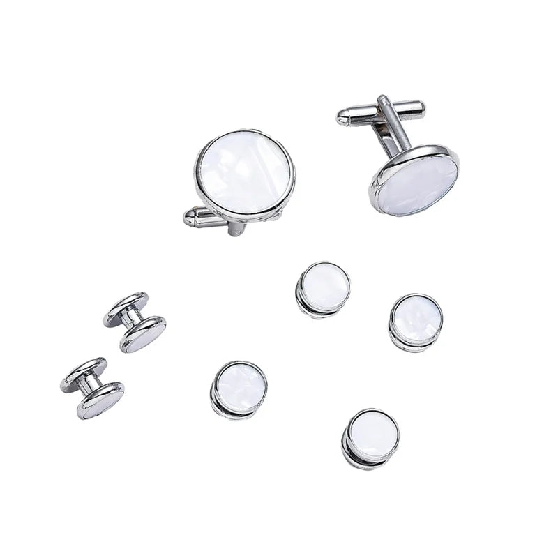 Un set d'elegant boutons de manchette et de serre-cravate en argent sur fond blanc.