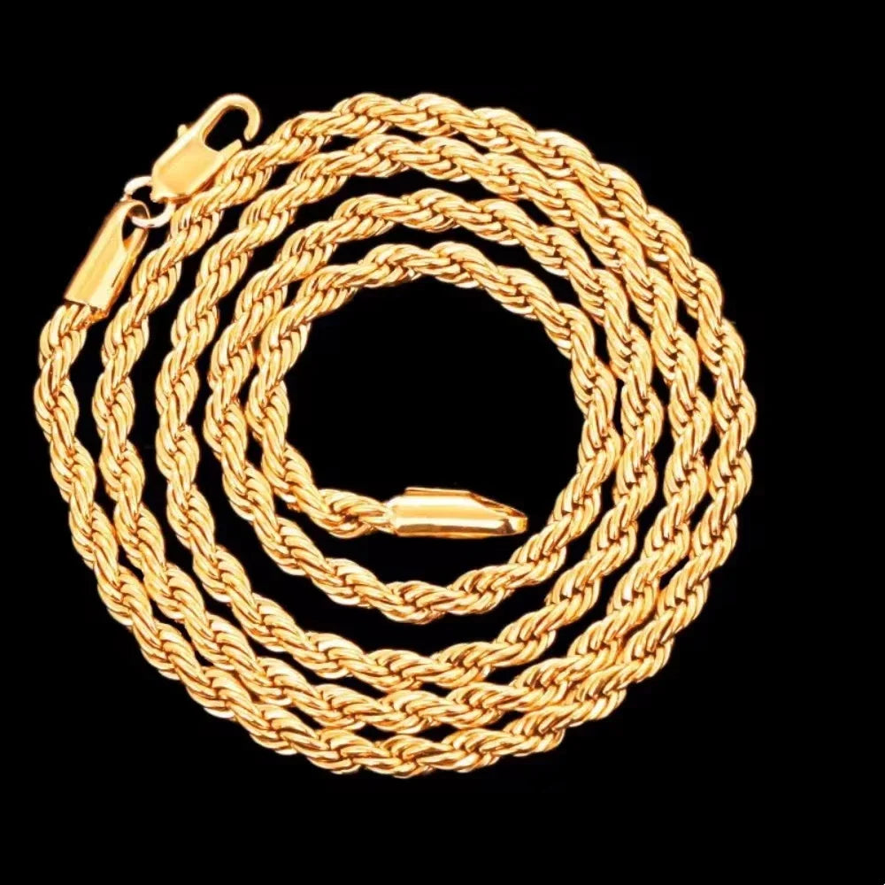 A close-up of a thick, braided 18K gold rope charm necklace coiled on a black background.