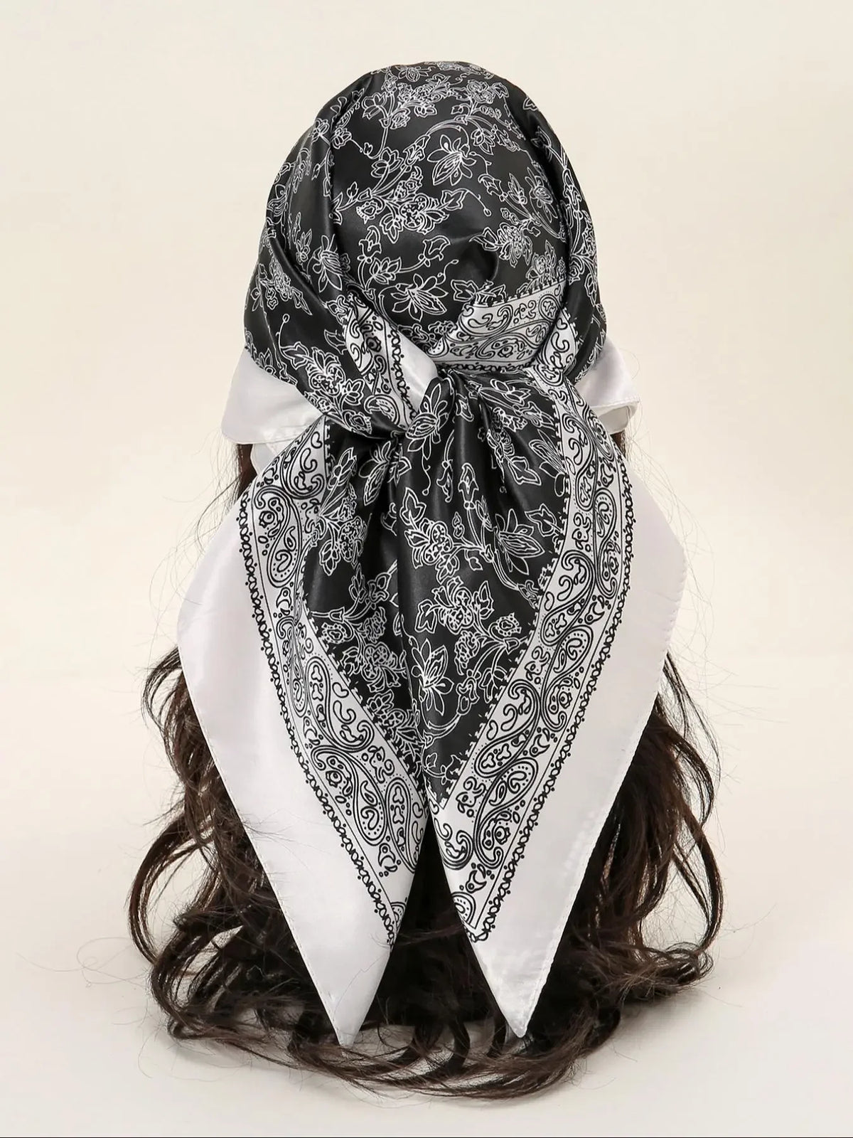 A black and white floral satin shawl tied around a dark hair