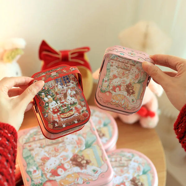 يد تحمل صندوق حلوى من صفيح وردي مزخرف بحلقة حمل، بخلفية ضبابية.