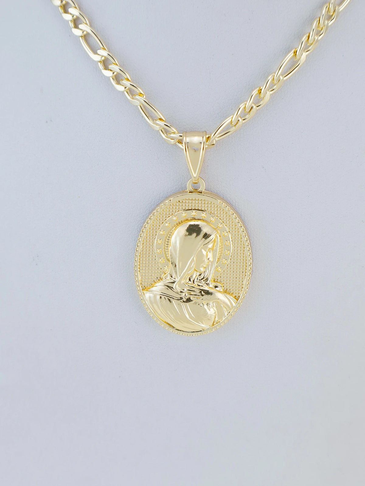 A gold-plated pendant necklace featuring a depiction of the Virgin Mary Christ.