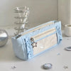A light blue lace pencil case is shown next to a silver pen holder and small decorative stars on a white surface.
