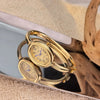 A pair of elegant gold-toned quartz watches with Roman numerals displayed on a reflective surface.