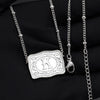 Silver initial letter pendant necklace with a chain and bail displayed on a black fabric background