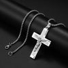 Silver cross amulet necklace with engraved text displayed on a dark background.