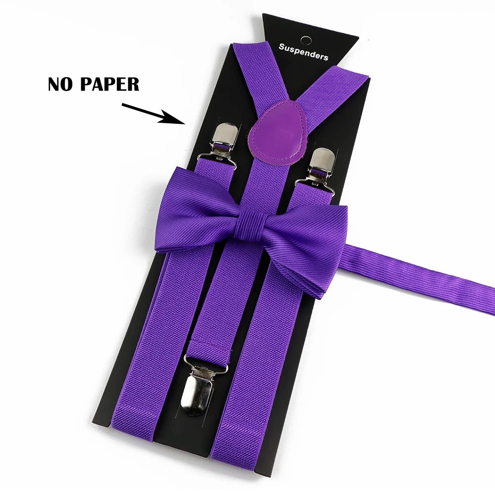 A set of purple polyester suspenders with bow ties and a purple suspender holder on a black card.