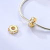 A sterling silver devil's eye charm bracelet featuring a gold-toned charm with clear stones.