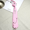 A pink tie with a silver chain star pendant is displayed on a light gray fabric.