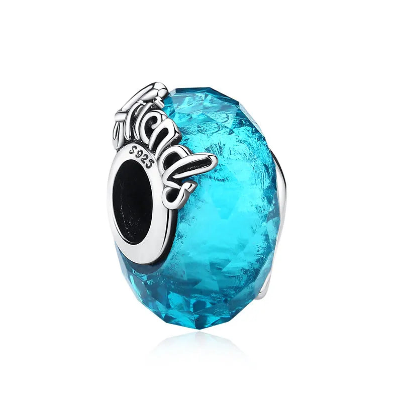 A faceted blue gemstone with a silver family tree charm set in 925 sterling silver jewelry.