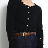 Black long-sleeved shirt and dark denim jeans paired with an elegant brown leather belt.