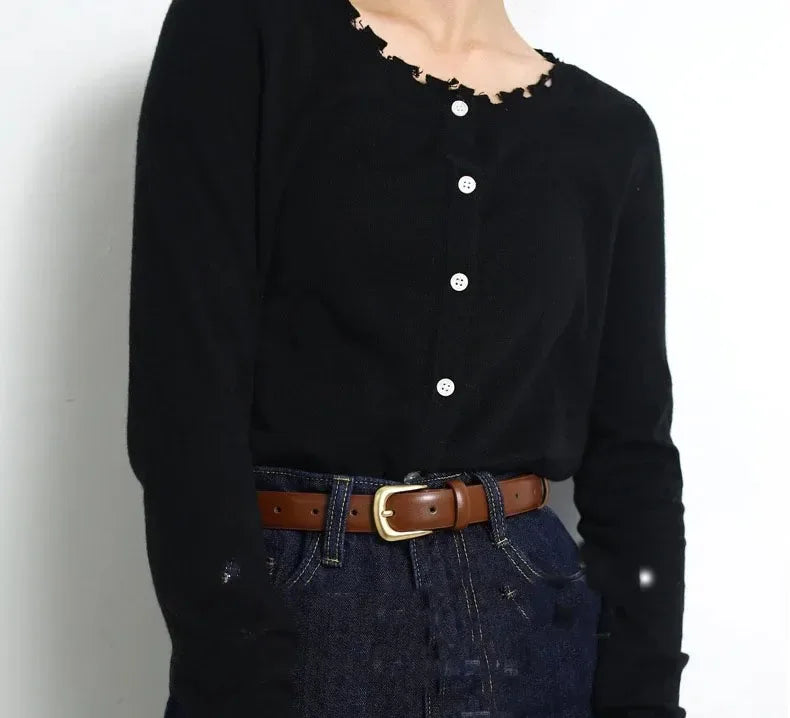 Black long-sleeved shirt and dark denim jeans paired with an elegant brown leather belt.