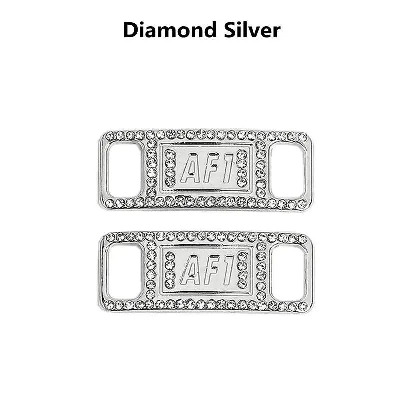 A pair of diamond silver shoe charms and laces featuring the letter AF1 stamped on them.