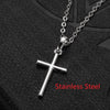 Silberne Edelstahlkreuz-Halskette und Ohrringe-Set auf dunker strukturierter Oberfläche.