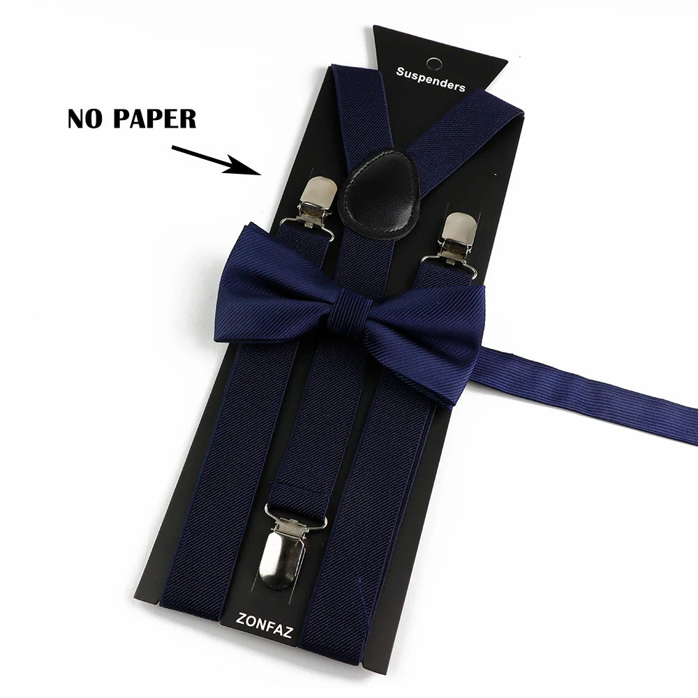 A black suspenders set with a navy blue bow tie and strap, featuring a silver buckle.
