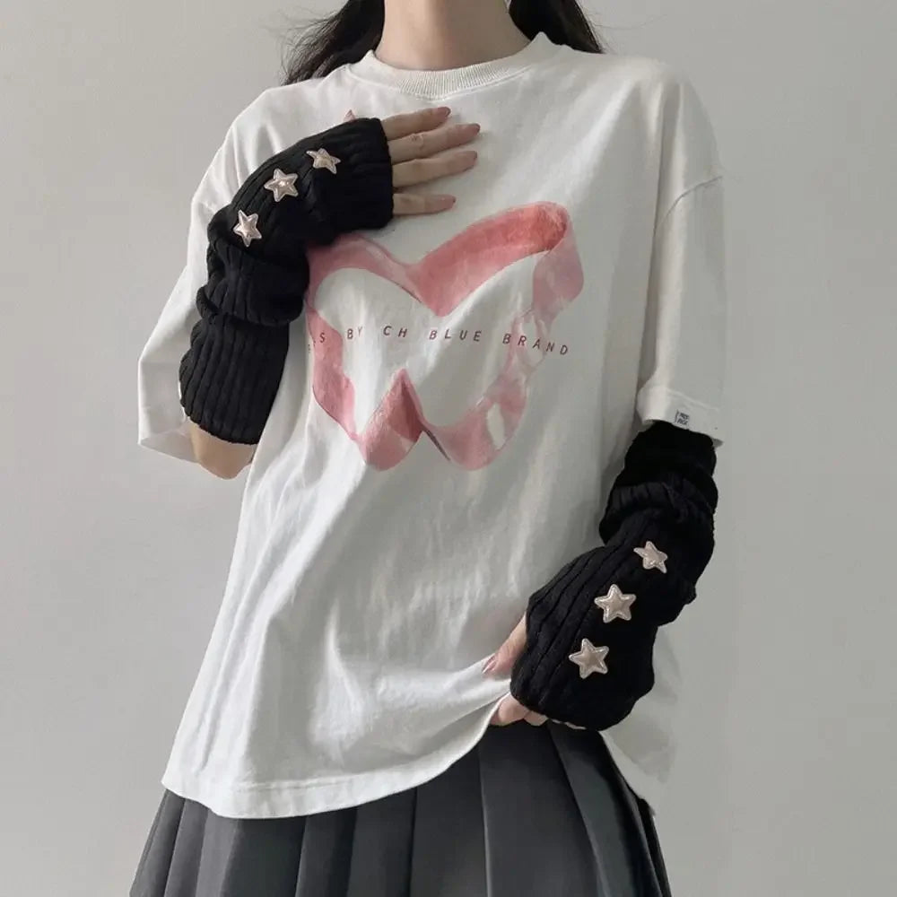 A person wearing a white t-shirt and dark fingerless arm warmers with star details.