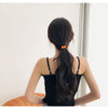 A woman with long dark hair tied in a ponytail wearing a black top, shown from the back.