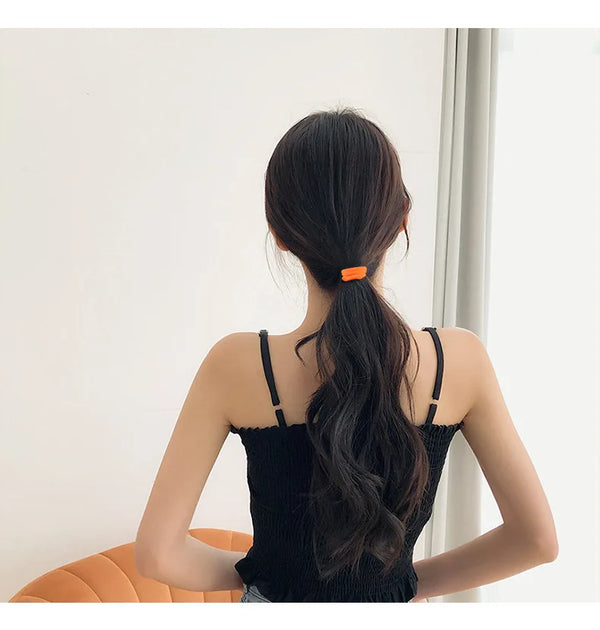 A woman with long dark hair tied in a ponytail wearing a black top, shown from the back.